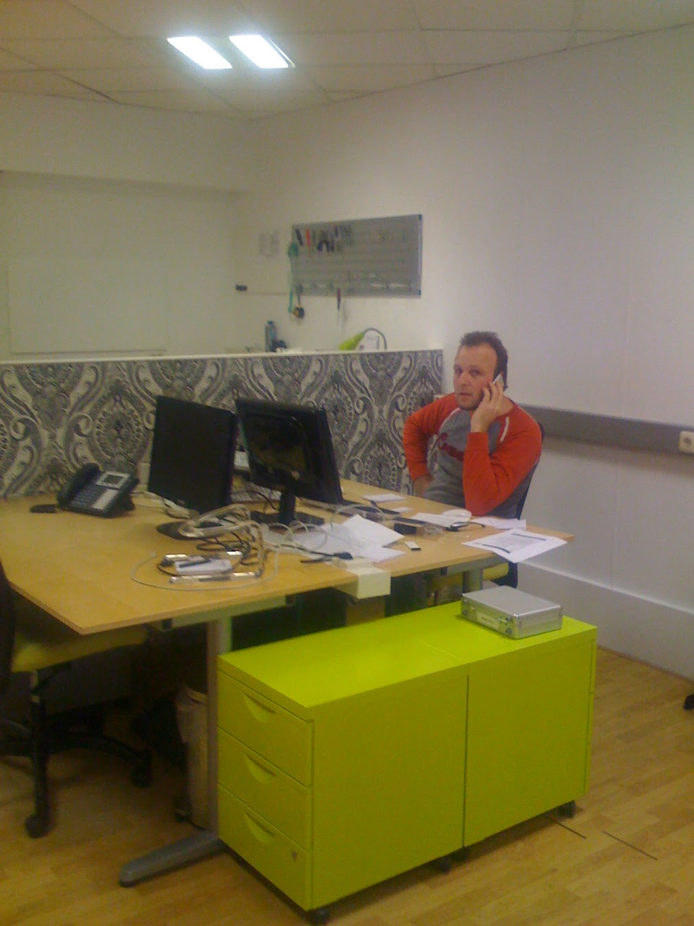 Een jongere Dennis aan de telefoon achter zijn bureau in het MacHelp-pand aan de Venestraat, foto uit de begintijd